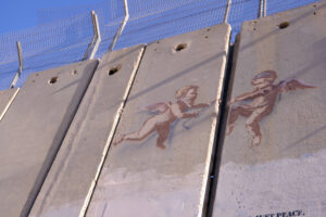 two angels trying to pull apart the 26 foot high cement wall that surrounds Bethlehem